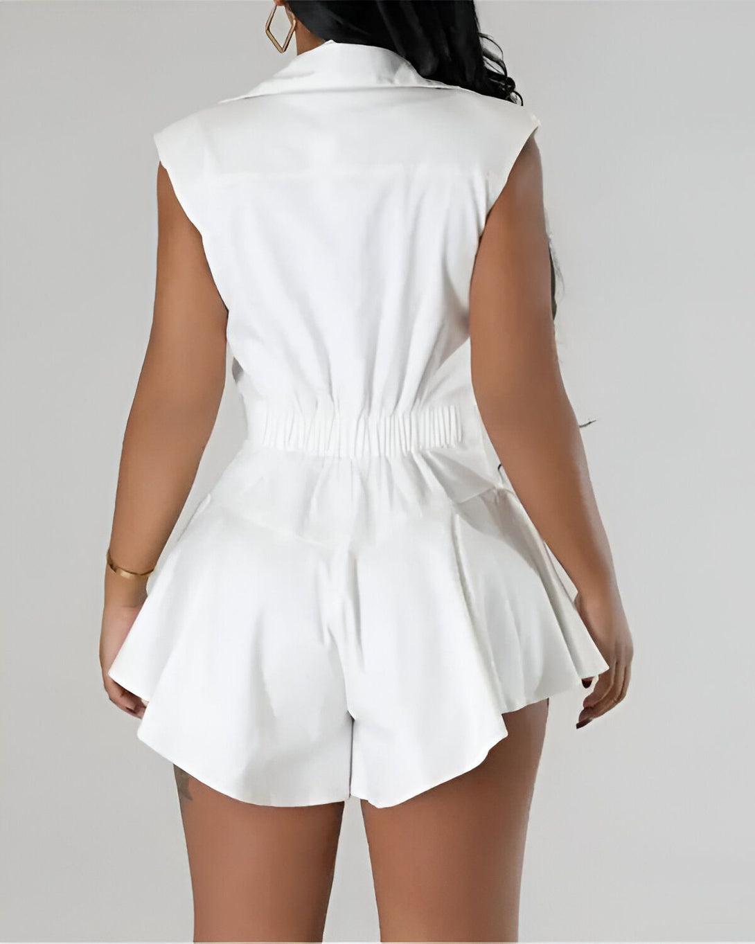 Une combinaison short taille haute blanche pour femme avec un haut à col montant et des manches courtes bouffantes.