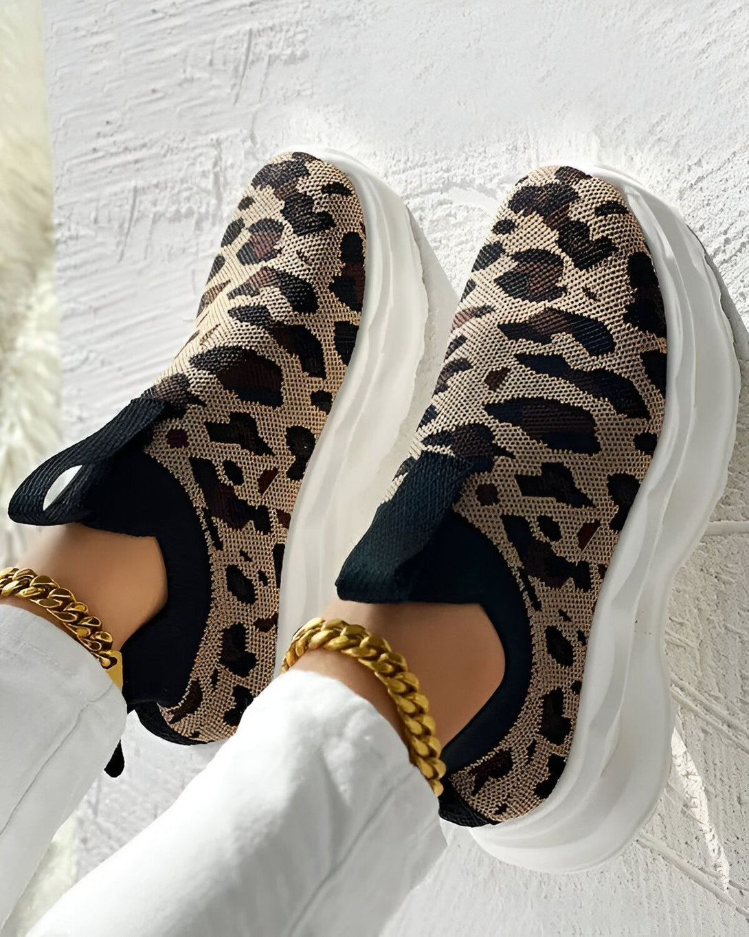 Une paire de baskets léopard avec des lacets noirs et une semelle blanche.