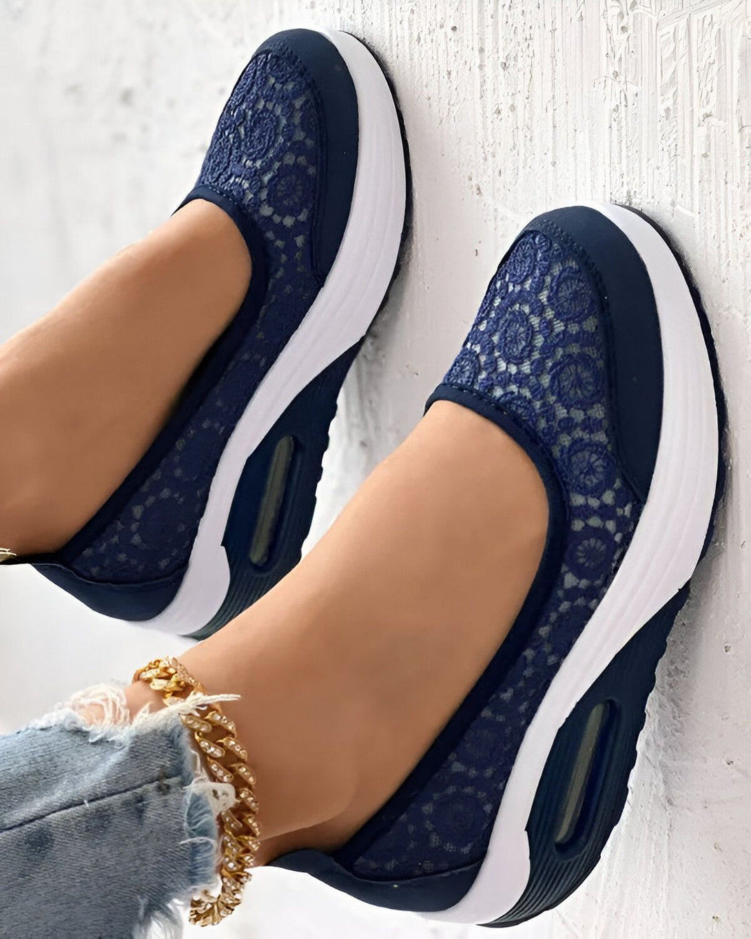 Une femme porte des baskets bleues en dentelle. Les baskets sont légères et respirantes, idéales pour le printemps et l'été.