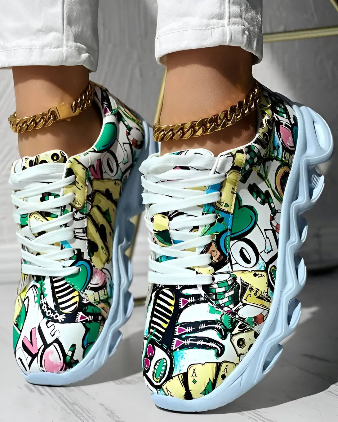 Une paire de baskets colorées avec des lacets blancs et une semelle épaisse. Les baskets sont recouvertes de motifs de dessins animés et de graffitis.