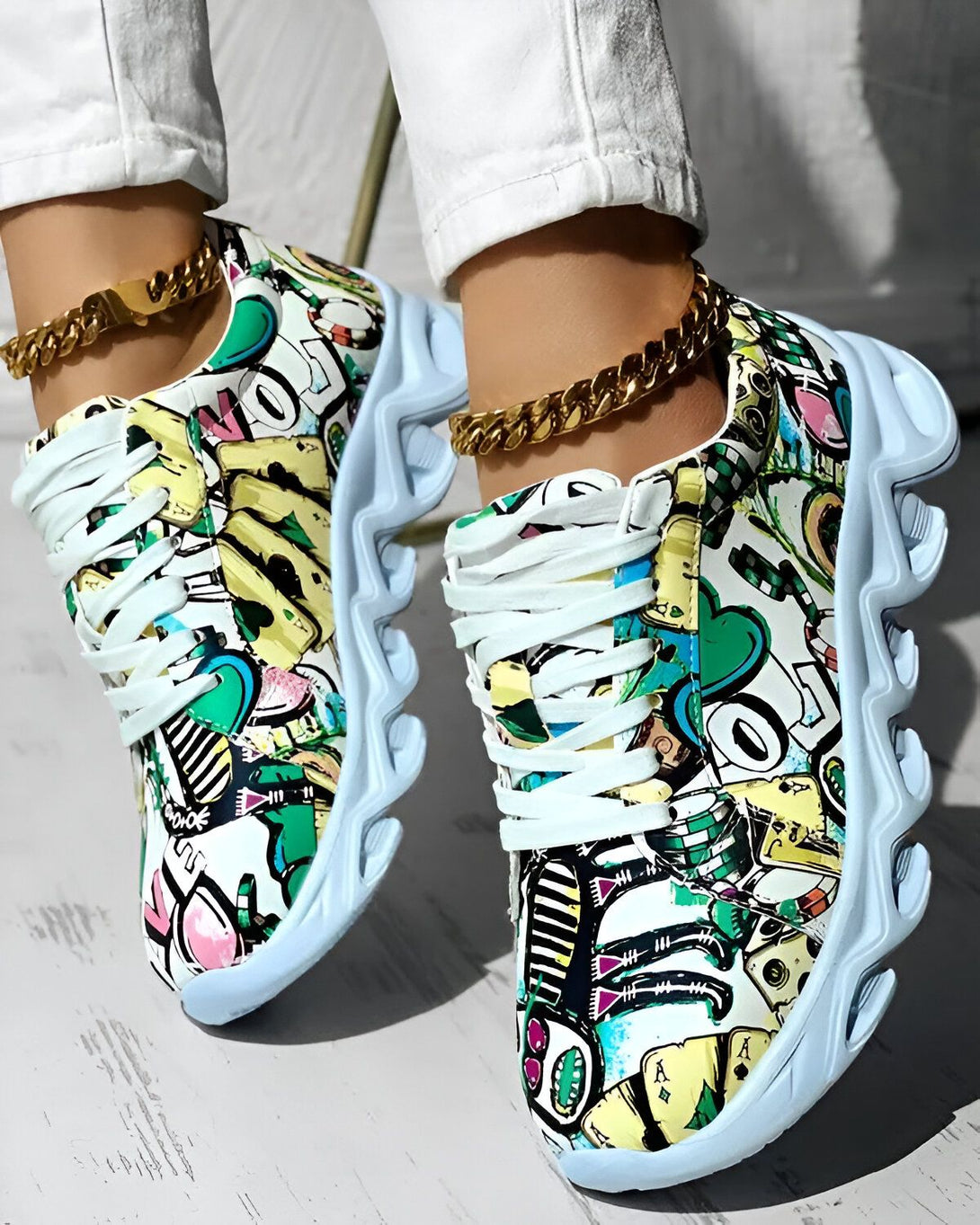 Une paire de baskets colorées avec des lacets blancs et une semelle épaisse. Les baskets sont recouvertes de motifs de dessins animés et de graffitis.