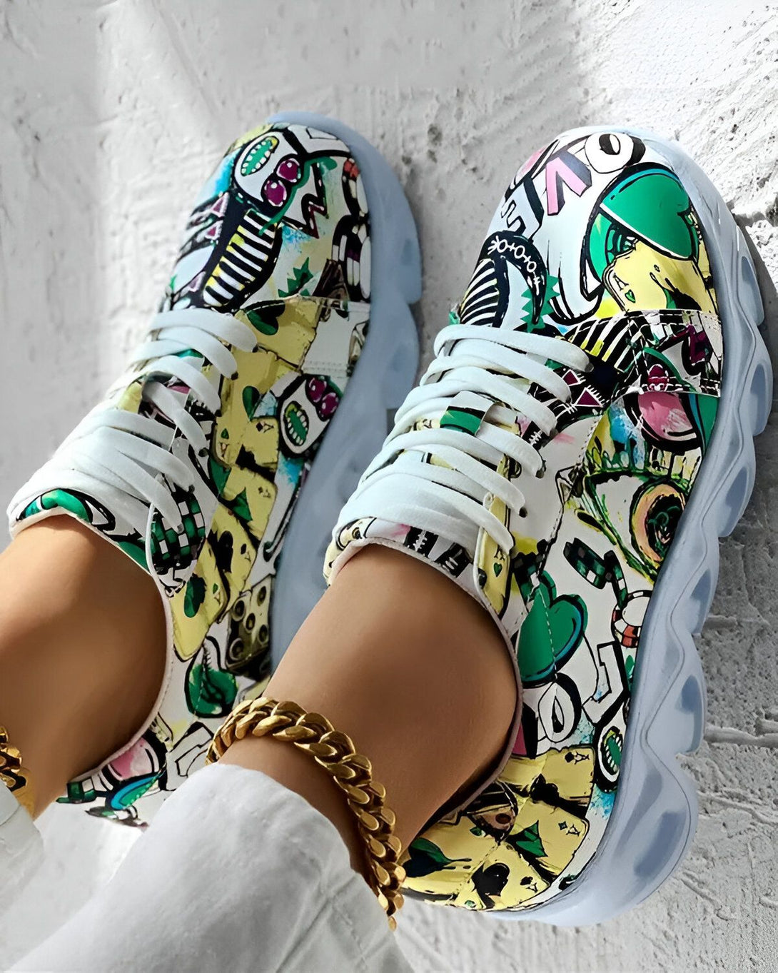 Une paire de baskets montantes colorées avec des lacets blancs. Les baskets sont recouvertes de graffitis et de dessins colorés.