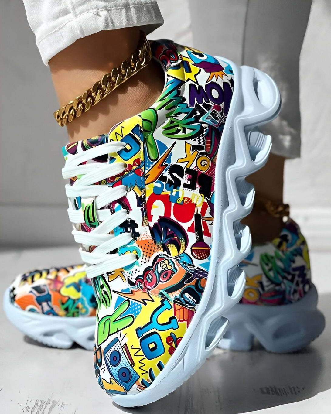 Une image d'une paire de baskets colorées avec des lacets blancs. Les baskets sont recouvertes de graffitis et de motifs colorés.
