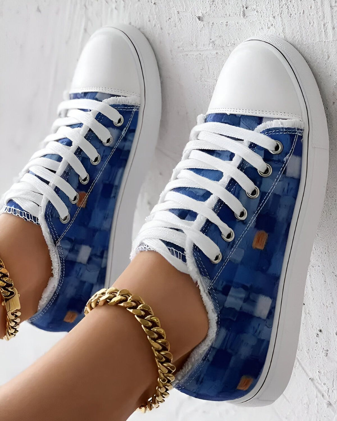 Une paire de sneakers montantes bleues et blanches avec des lacets blancs.