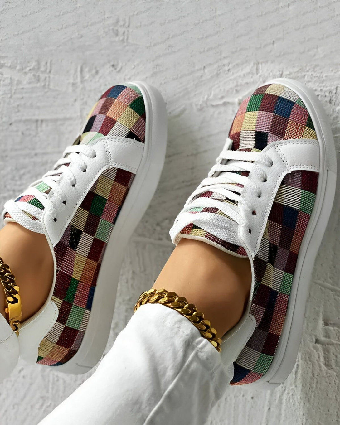 Une paire de baskets en patchwork de couleurs vives avec des lacets blancs et une semelle blanche.