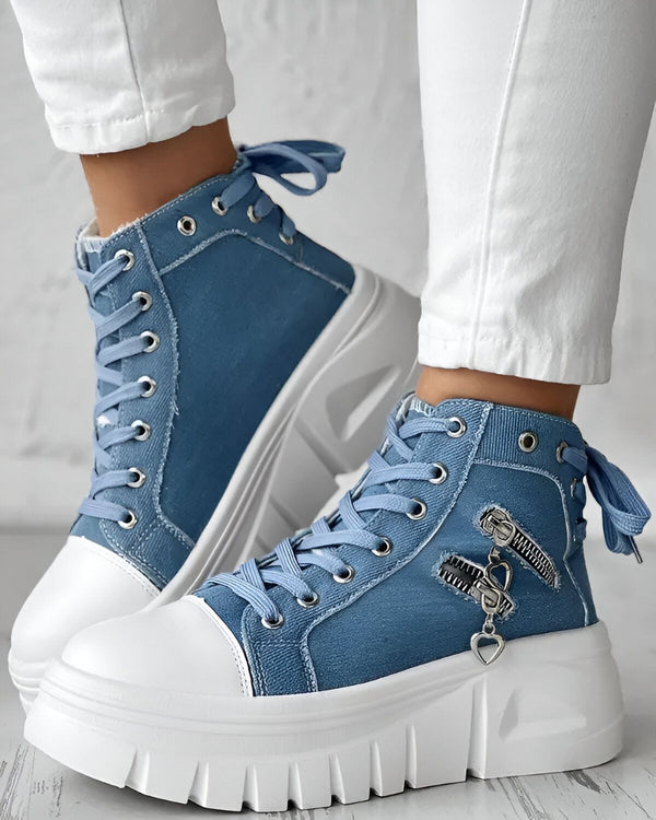 Une paire de chaussures montantes en jean bleu avec des lacets et une fermeture éclair sur le côté.
