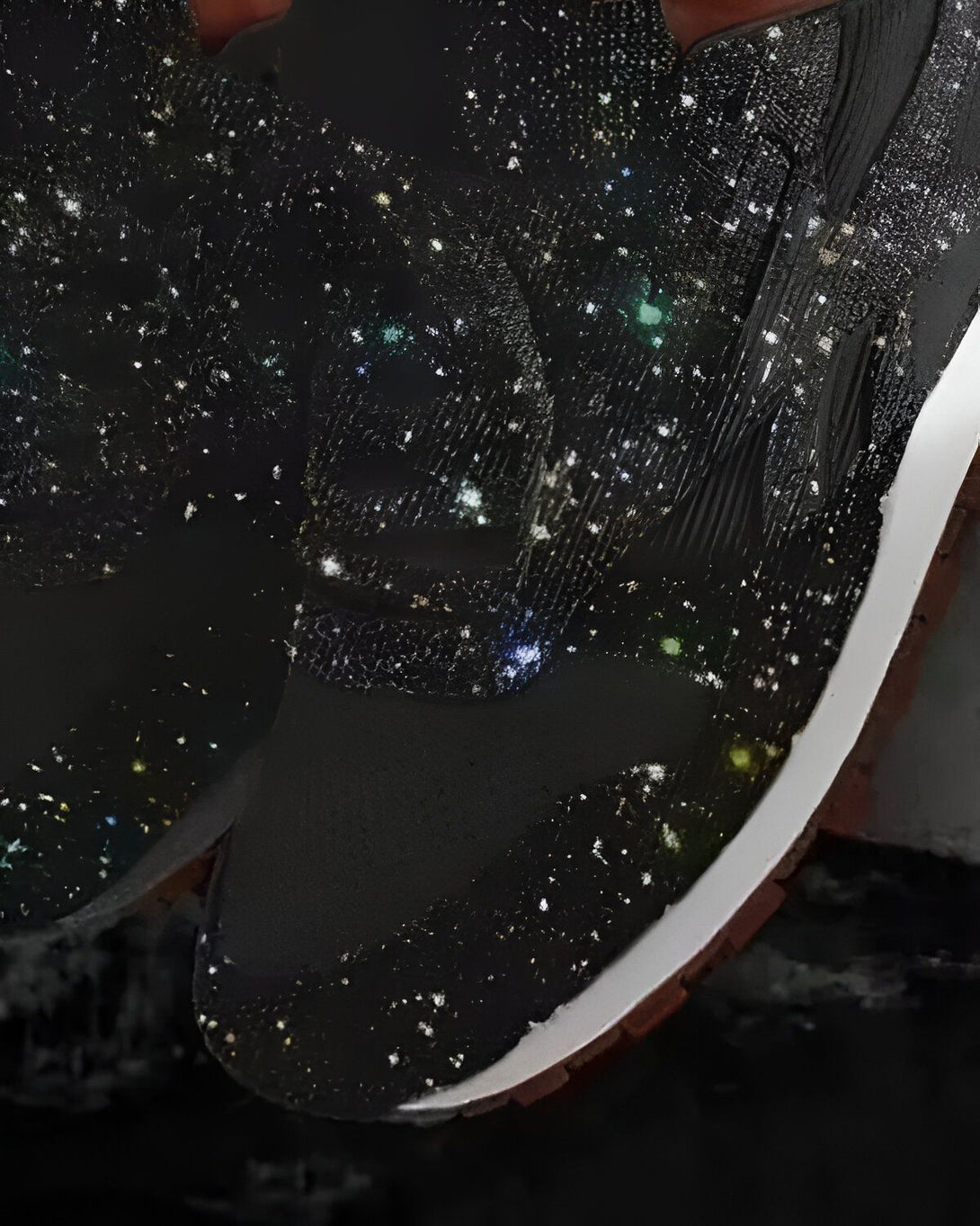 Une paire de sneakers noires avec des étoiles colorées.