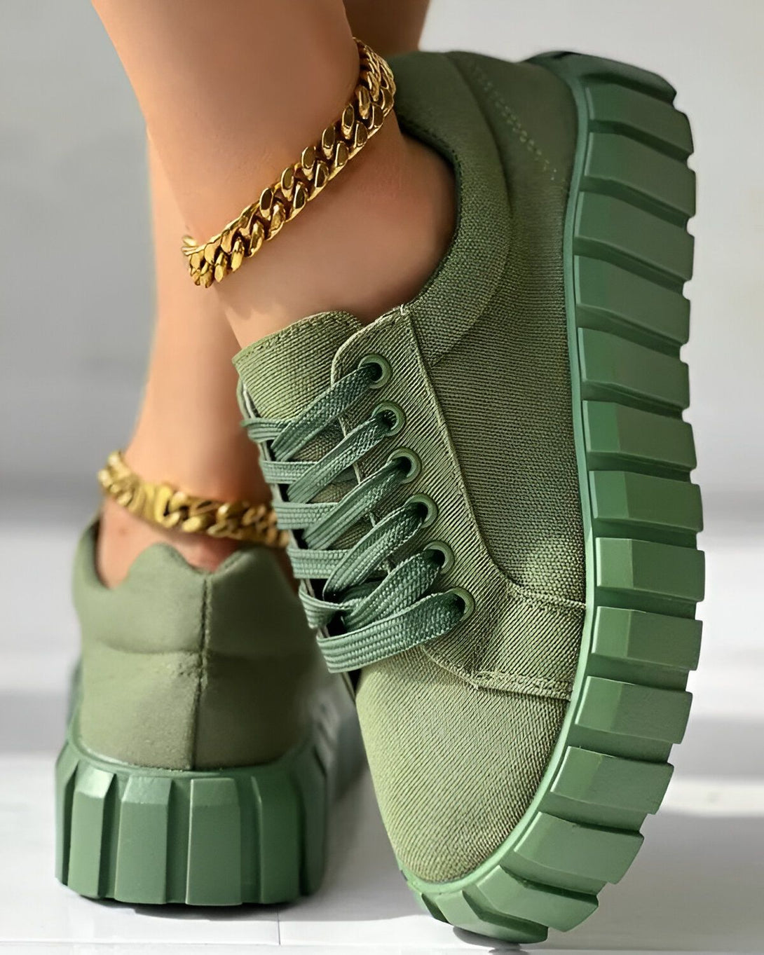 Une paire de sneakers verte avec des lacets et une semelle crantée.