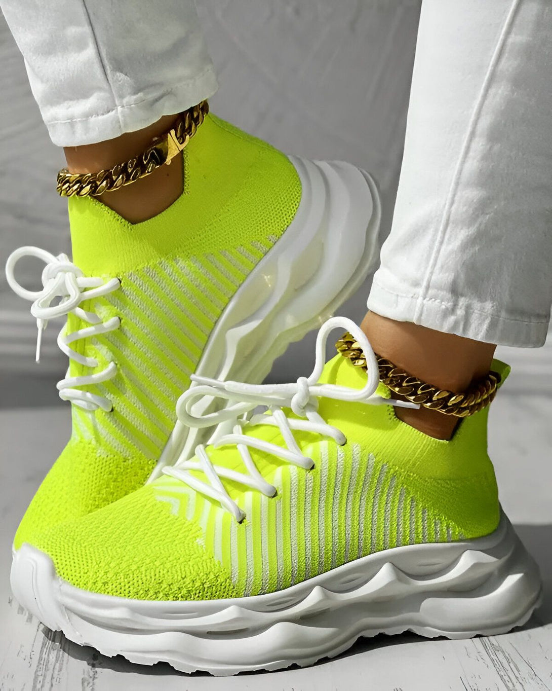 Une paire de baskets vert fluo avec des lacets blancs et une semelle blanche.