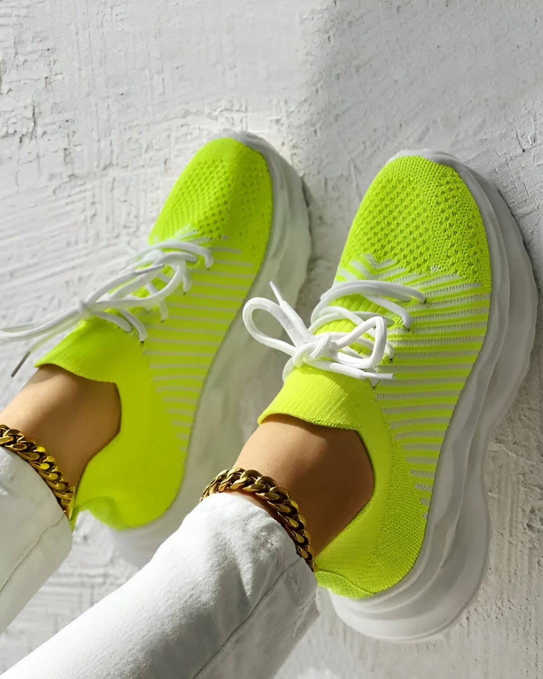 Une paire de baskets vert fluo avec des lacets blancs et une semelle blanche.