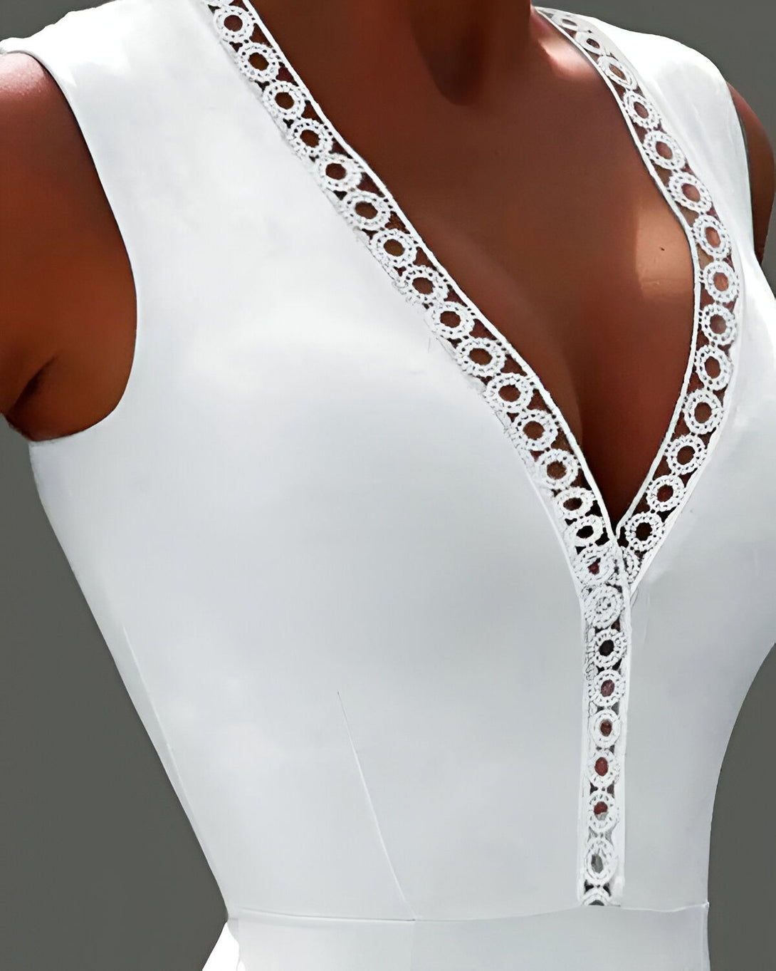 Une femme porte un justaucorps blanc avec un décolleté plongeant et des détails en dentelle.