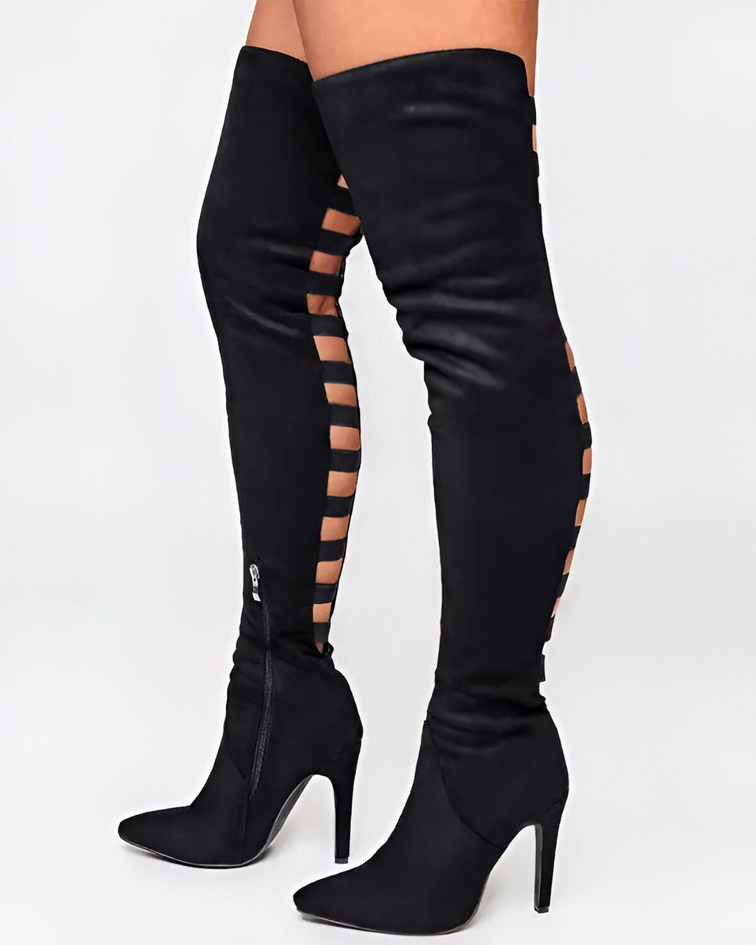 Une femme porte des bottes noires à talons hauts. Les bottes sont montantes et ont des découpes sur les côtés.