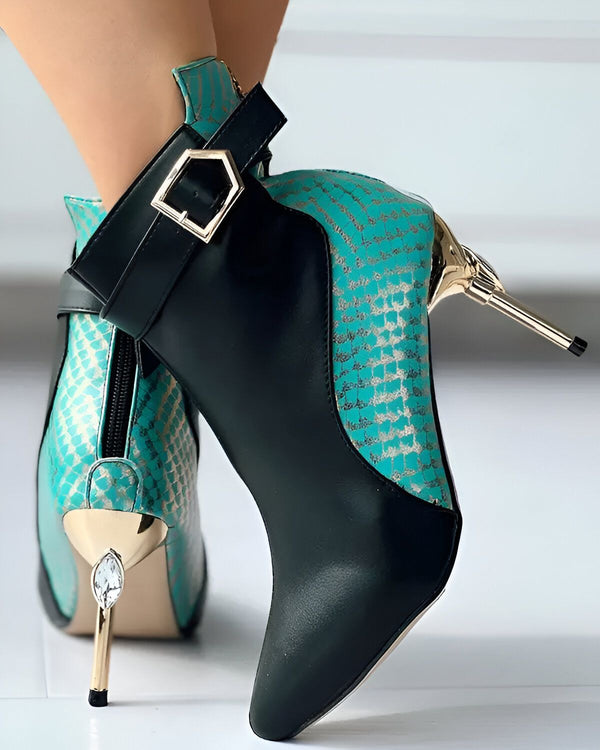 Une paire de bottes à talons hauts de couleur turquoise et noire. Les bottes sont en cuir de serpent et ont une boucle sur le côté.