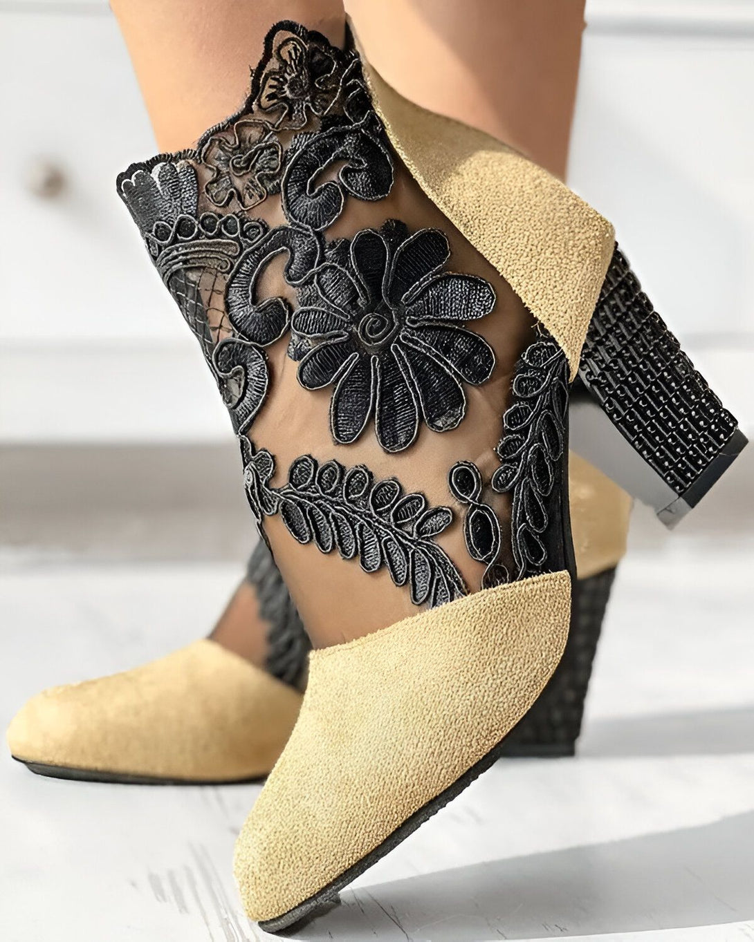 Une image de chaussures à talons hauts beiges avec des détails en dentelle noire.