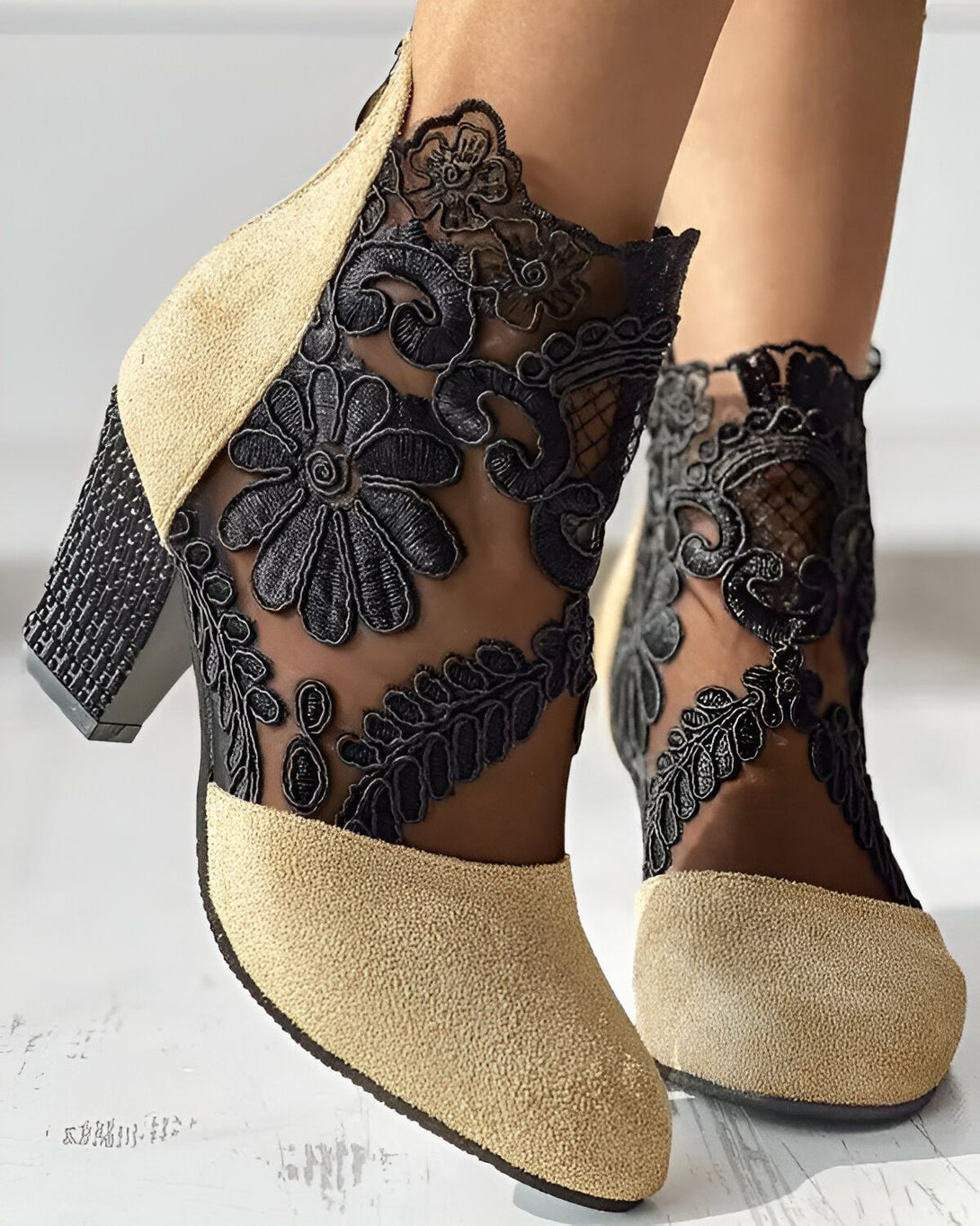 Une paire de chaussures à talons hauts beige et noir avec des fleurs en dentelle noire.