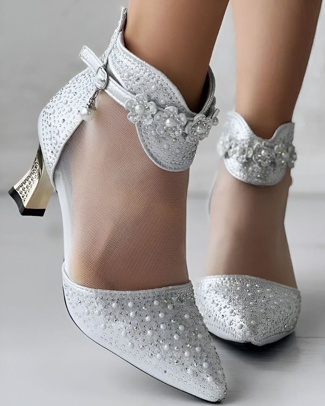 Une paire d'escarpins argentés à talons hauts avec des fleurs en perles sur le dessus.
