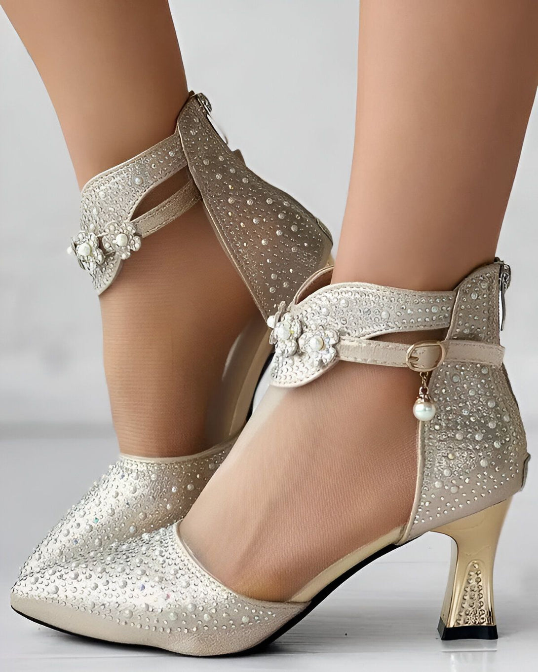 Une paire d'escarpins argentés à talons hauts avec des fleurs en strass sur le dessus.