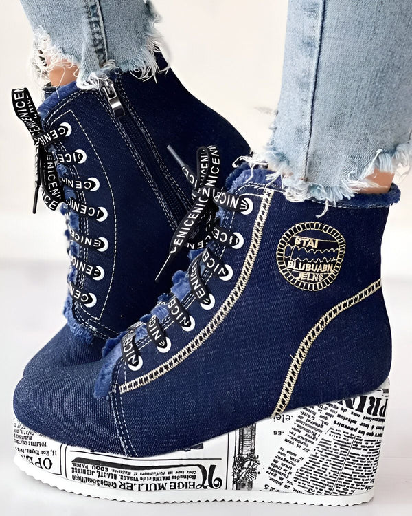 Une paire de bottines compensées en jean bleu avec des lacets blancs et une fermeture éclair sur le côté.