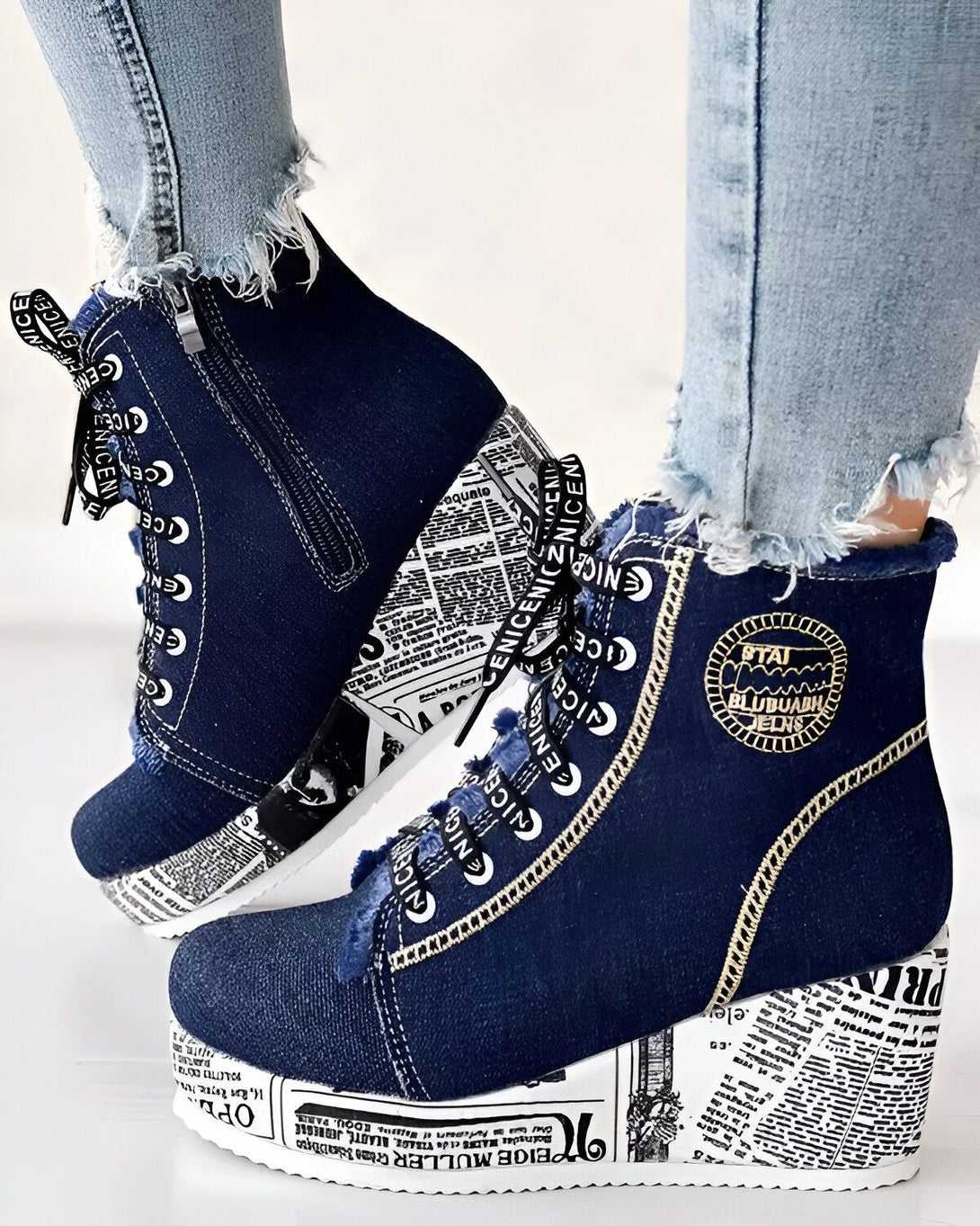 Une paire de bottes compensées en jean bleu avec des lacets blancs et une fermeture éclair sur le côté.