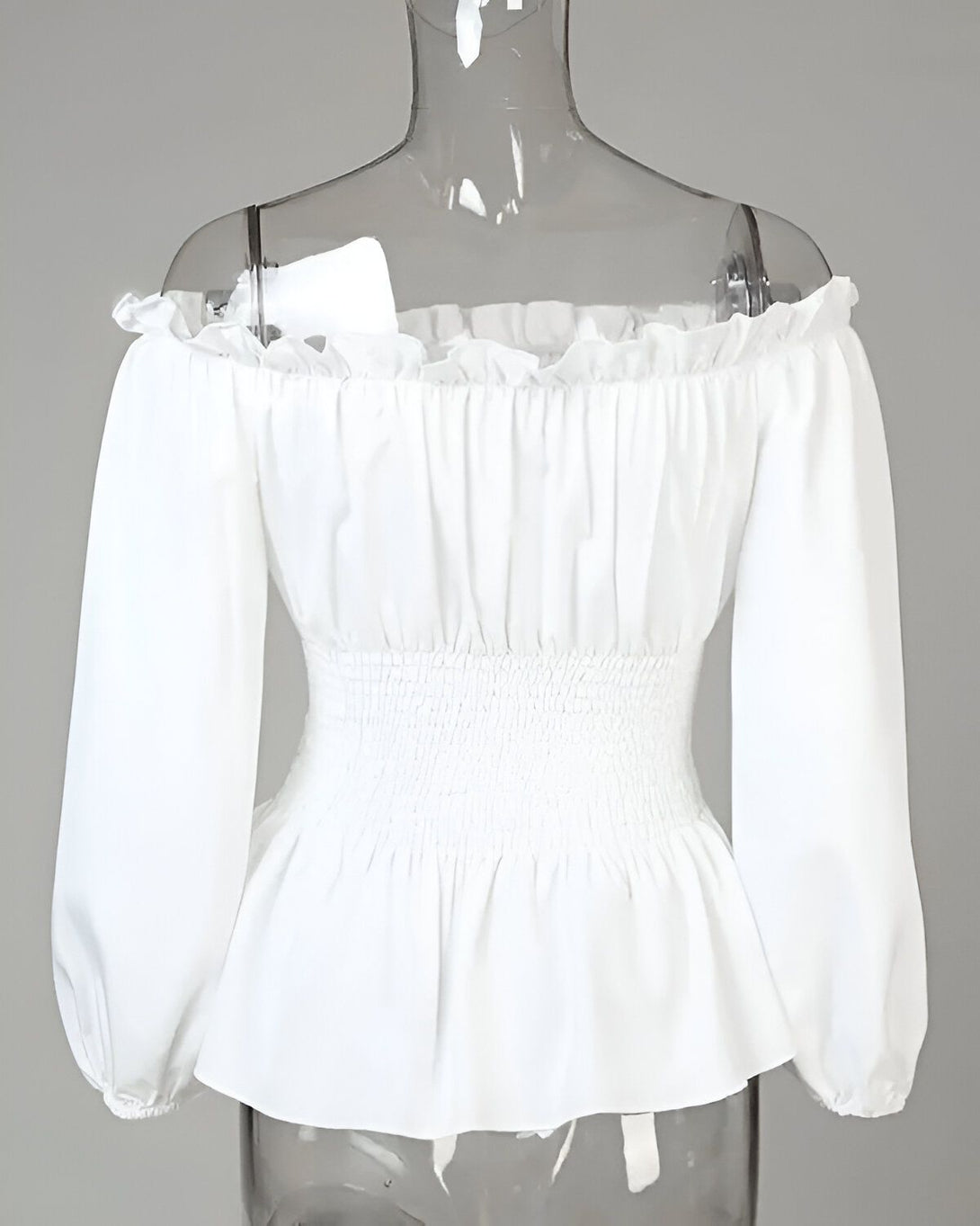 Chemisier blanc à épaules dénudées et à manches longues bouffantes. Le chemisier est cintré à la taille.