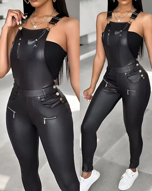 Une femme porte une combinaison pantalon en cuir noir. La combinaison est ajustée et possède des bretelles. Elle est associée à un débardeur noir. La femme porte également des baskets blanches et un collier.