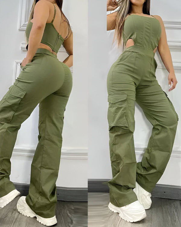 Une femme porte un pantalon cargo vert olive taille haute avec une brassière assortie. Le pantalon est ample et a des poches cargo sur les côtés. La brassière est courte et a une encolure carrée. La femme est debout, de dos à la caméra, et porte des baskets blanches.