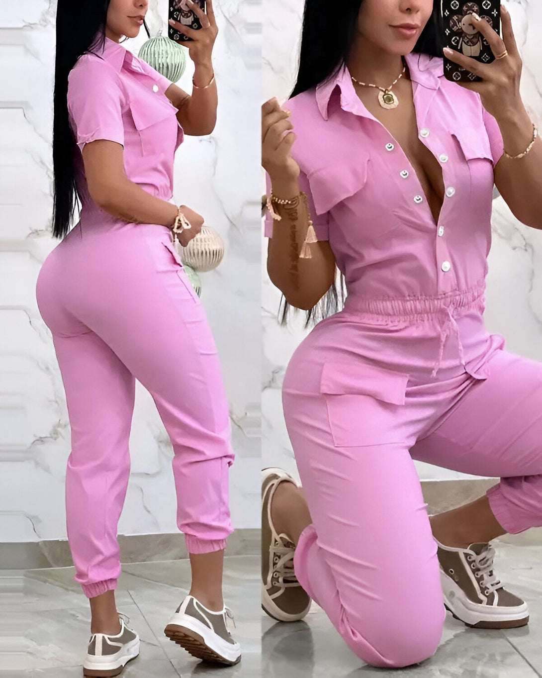 Une femme porte une combinaison rose. La combinaison est courte et a des manches courtes. Elle est cintrée à la taille et a un col montant. La femme est debout et pose pour la photo. Elle a les cheveux longs et noirs et porte des baskets blanches.