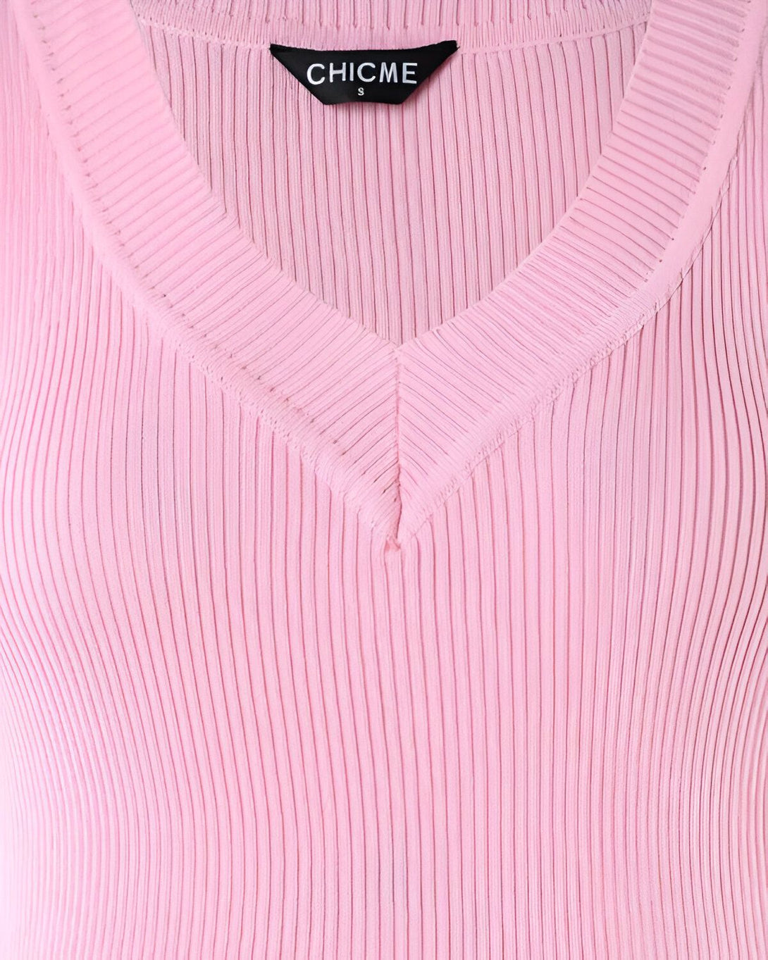 Une image d'un haut côtelé rose avec un col en V. Le haut est de la marque Chicme et est disponible en taille S.