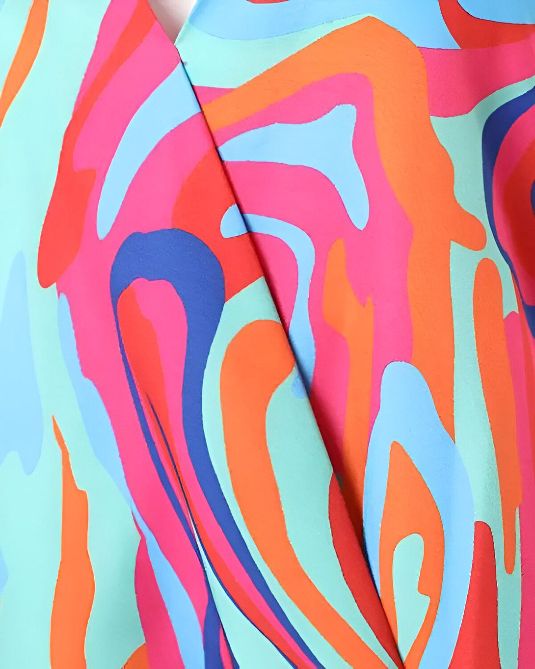 Une image d'un tissu coloré avec des motifs abstraits. Les couleurs principales sont le rose, le bleu et l'orange.