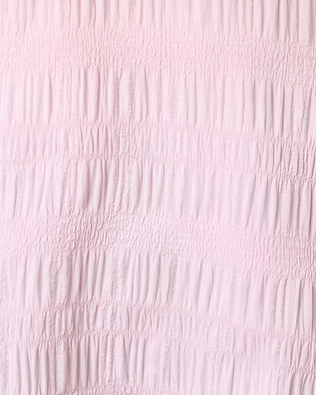 Une image d'un tissu rose pâle avec des plis horizontaux.