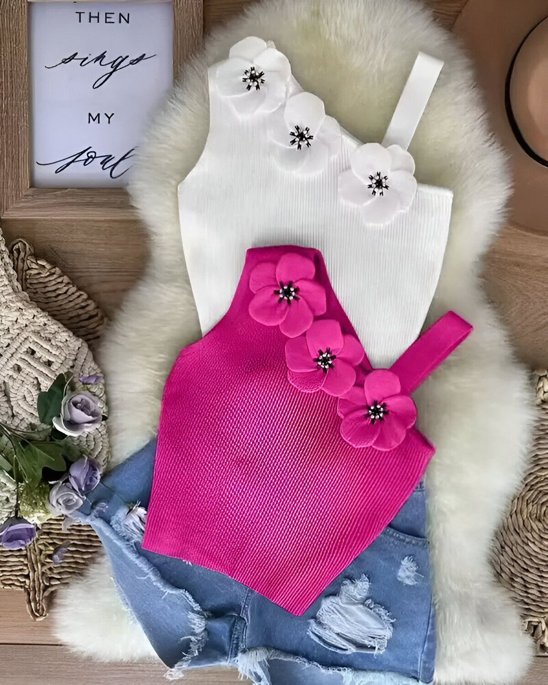 Un haut blanc avec des fleurs en relief sur l'épaule et un bas rose fuchsia côtelé.