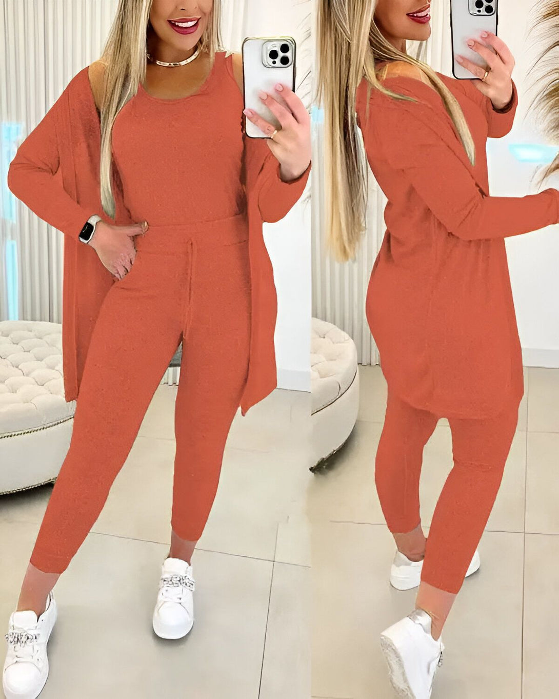 Une femme porte un ensemble de jogging orange composé d'un débardeur, d'un pantalon et d'un cardigan. Elle est debout devant un miroir et se prend en photo.