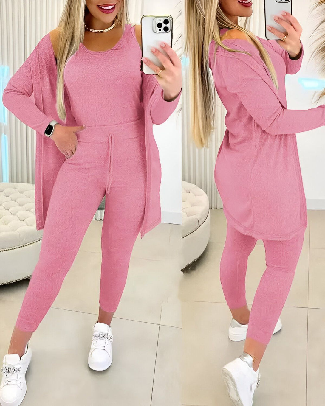 Une femme porte un ensemble de survêtement rose composé d'un débardeur, d'un pantalon et d'un cardigan. Elle est debout devant un miroir et se prend en photo.