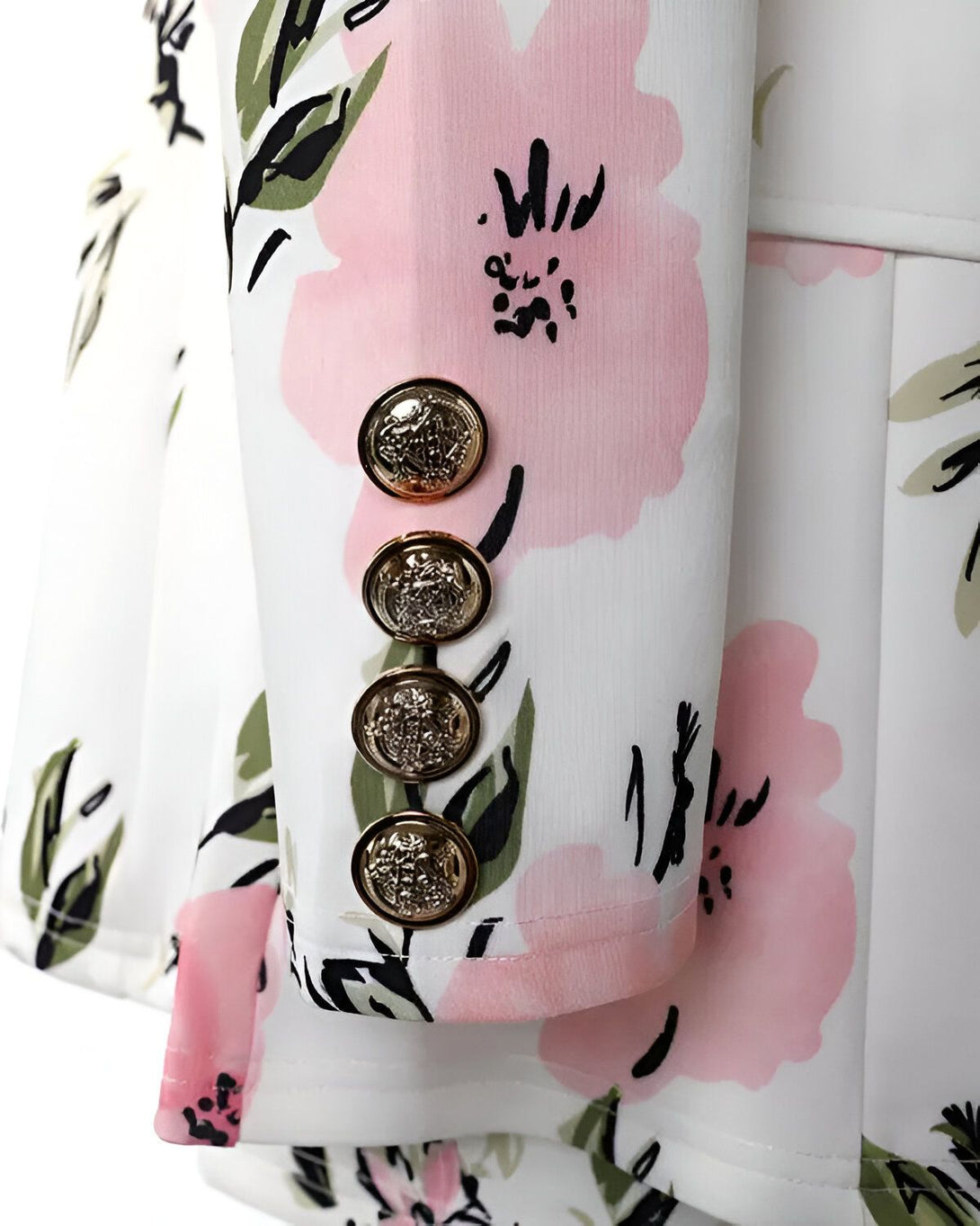 gros plan sur les boutons dorés d'une veste blanche à fleurs roses