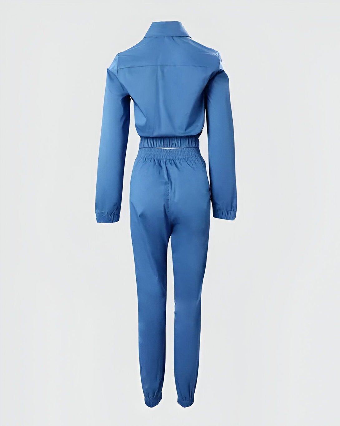 Une combinaison pantalon et veste de couleur bleu ciel avec des boutons blancs.