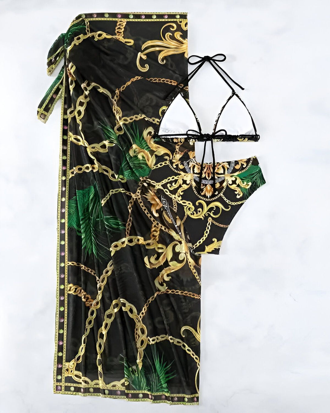L'image représente un maillot de bain deux pièces avec un paréo assorti. Le maillot de bain est de couleur noire et or avec un motif de chaînes et de feuilles de palmier. Le paréo est de couleur noire et transparente avec un motif de chaînes et de feuilles de palmier.