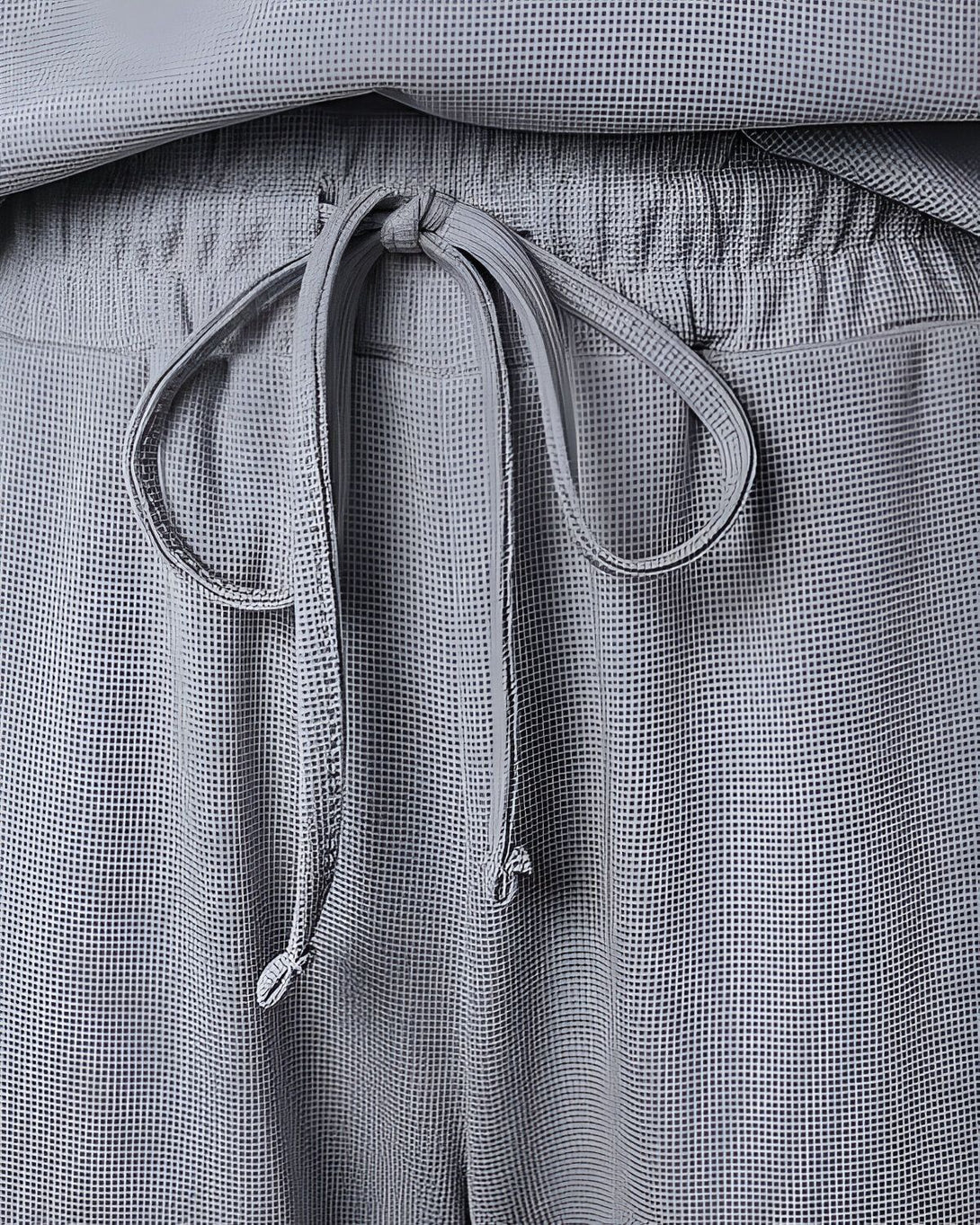 Le cordon de serrage à la taille du pantalon est noué.