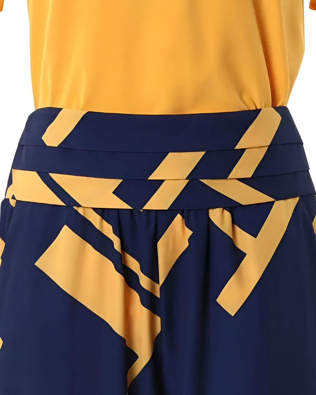 Une image d'un pantalon large bleu marine et jaune à motifs géométriques porté avec un haut jaune.