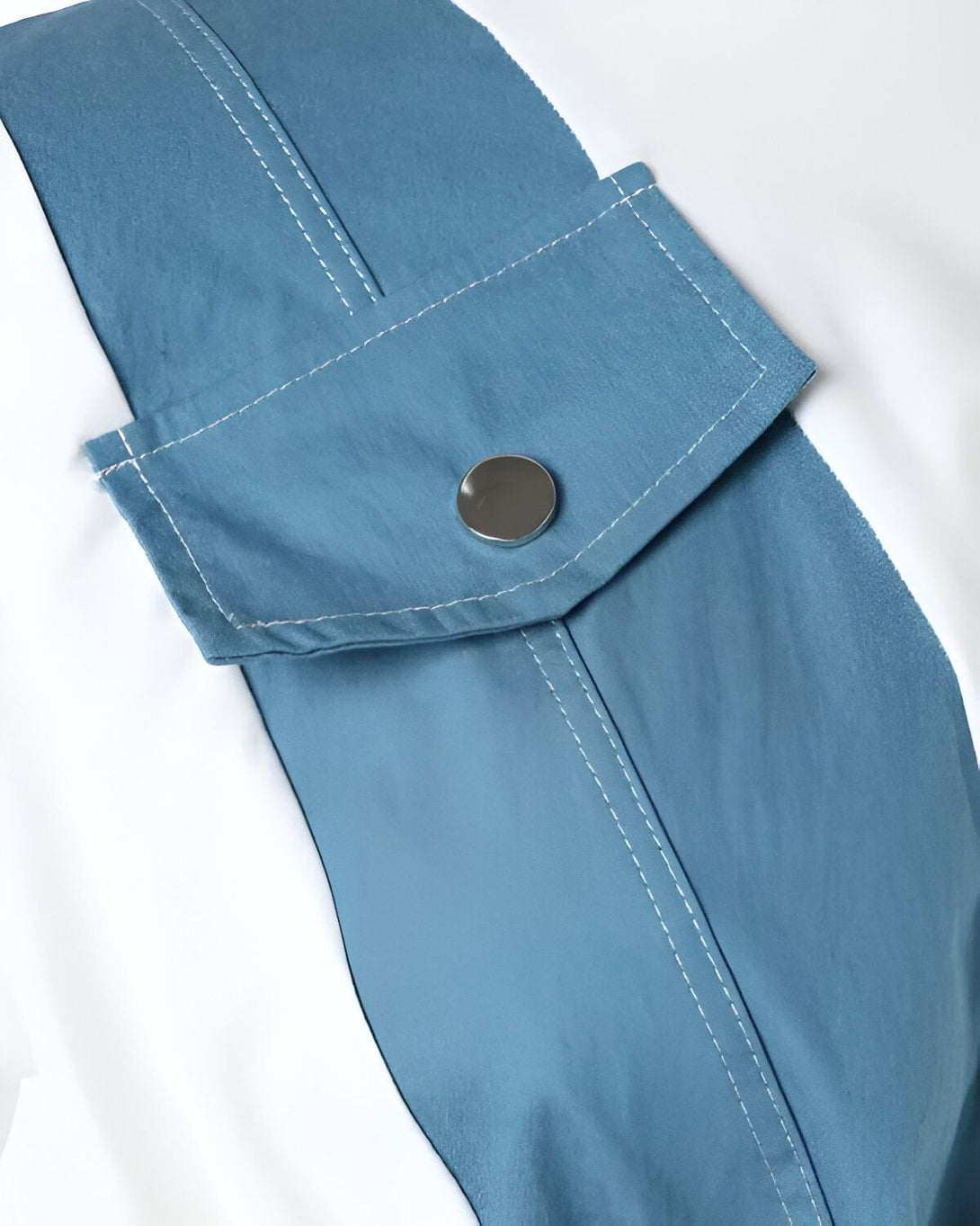 gros plan sur une poche de vêtement de couleur bleu ciel avec un bouton argenté