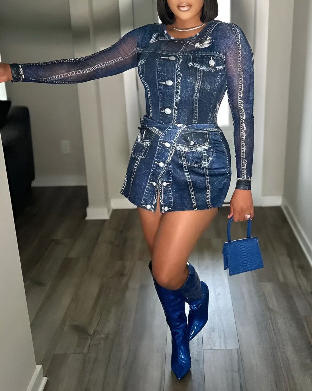 Une femme porte une robe en jean et des bottes bleues. Elle a un sac à main bleu et des bijoux argentés.