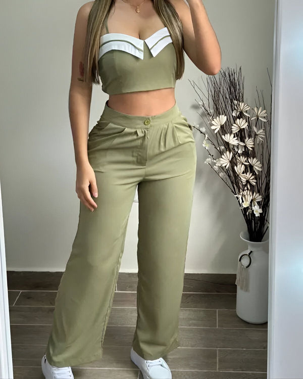 Une femme porte un ensemble pantalon et haut vert kaki. Le haut est court et possède un col blanc. Le pantalon est large et taille haute.