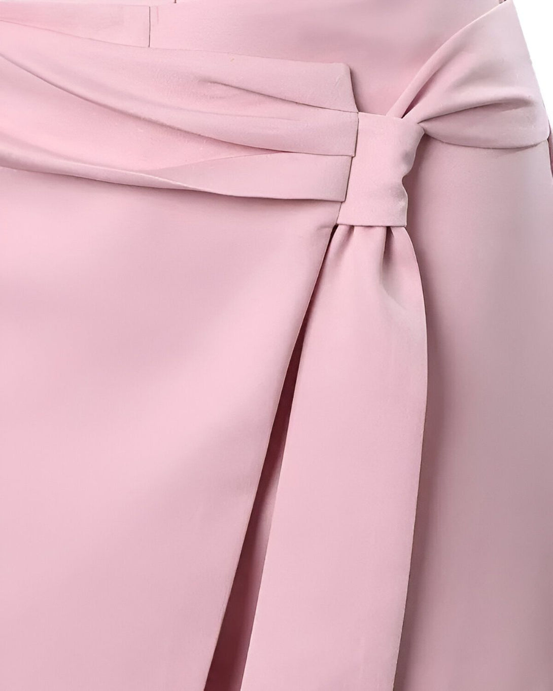 Une image d'une jupe portefeuille rose pâle. La jupe est nouée sur le côté avec un nœud.