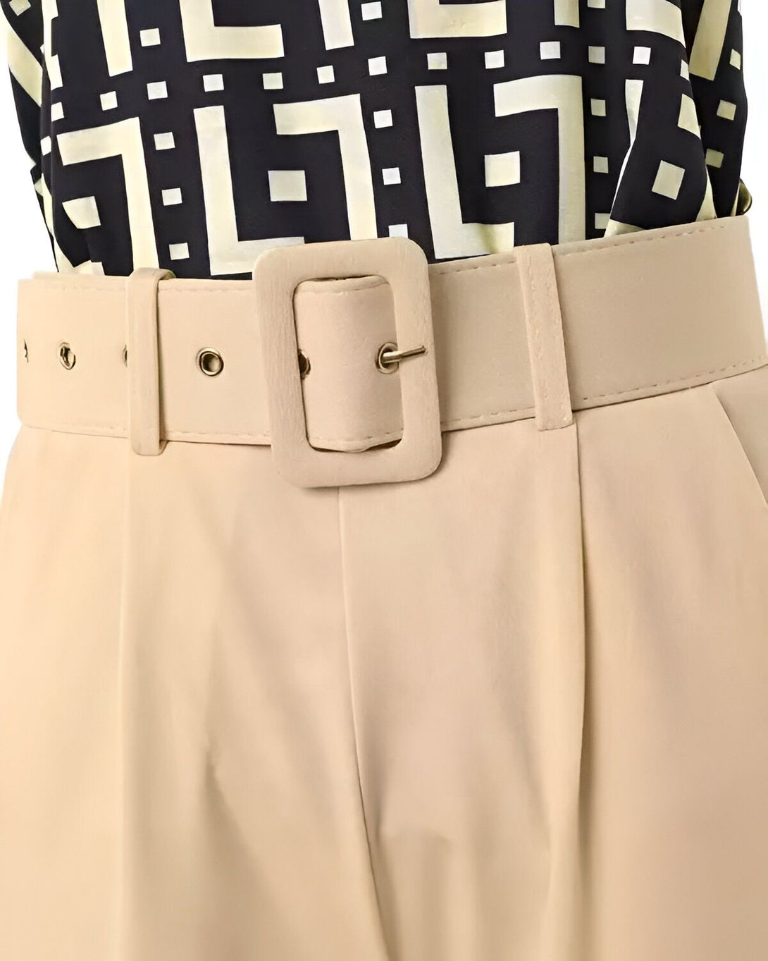 Une image d'un pantalon beige avec une ceinture marron. Le pantalon est taille haute et a des plis sur le devant. La ceinture est en similicuir et a une boucle carrée.