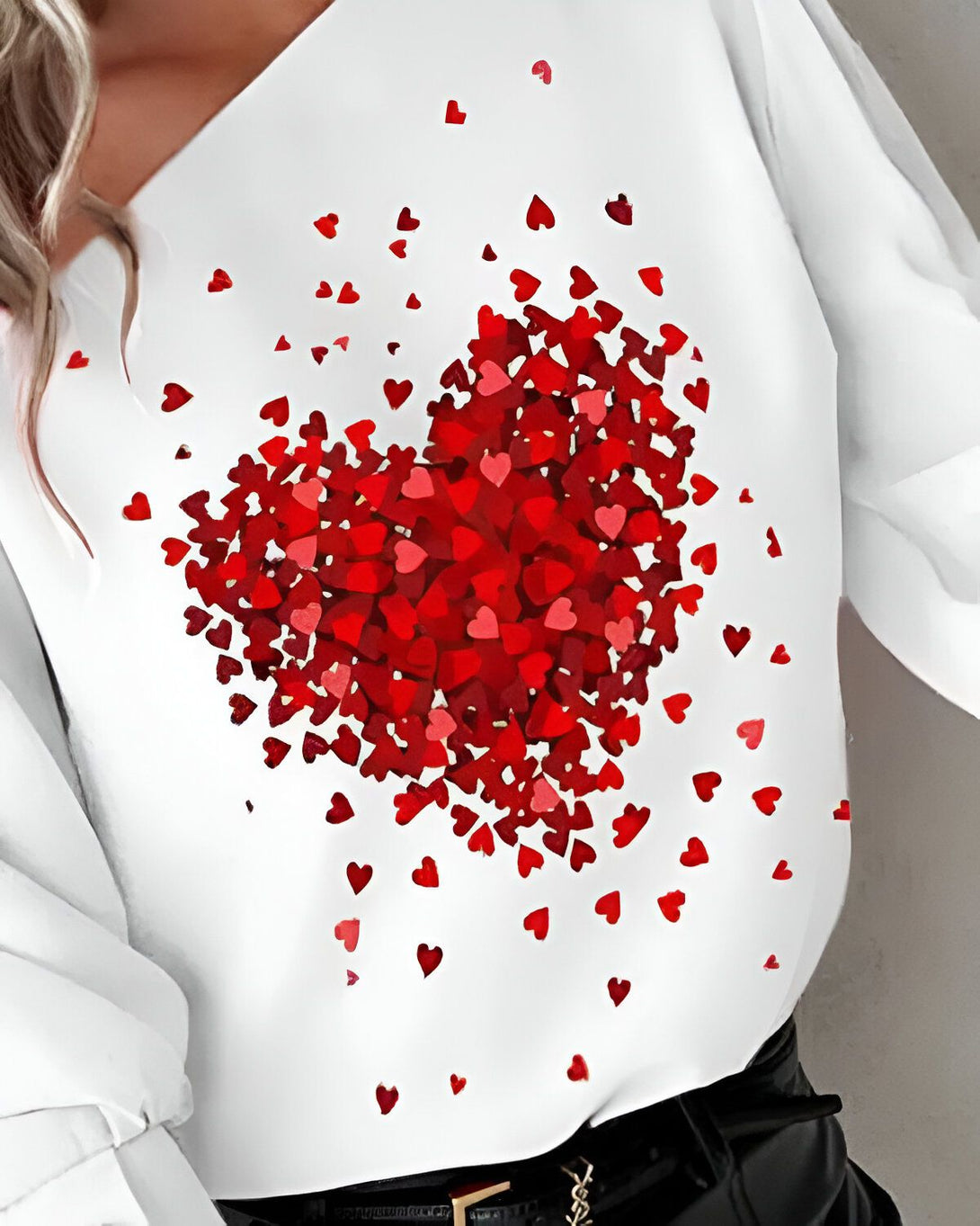 Une image d'une femme portant un chemisier blanc avec un motif de coeurs rouges.