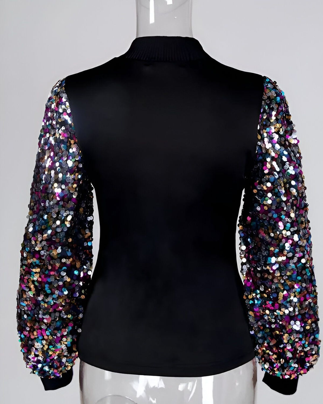 Une image d'un mannequin portant un chemisier noir à manches longues. Les manches sont ornées de sequins multicolores.