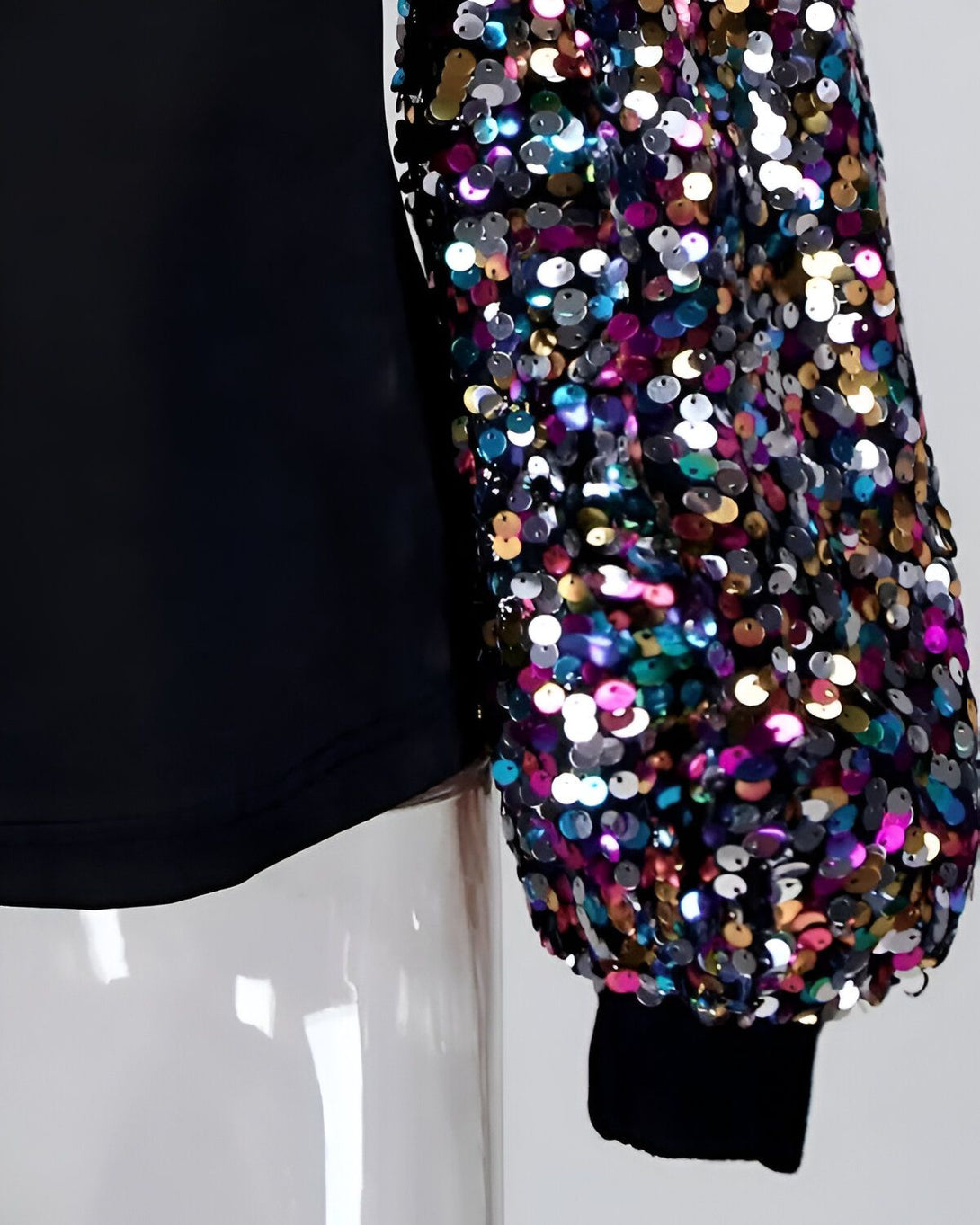 Une manche de vêtement est recouverte de sequins multicolores.