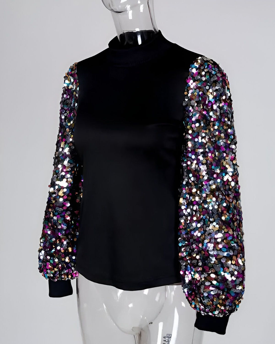 Le haut noir à col montant est orné de sequins multicolores sur les manches bouffantes.