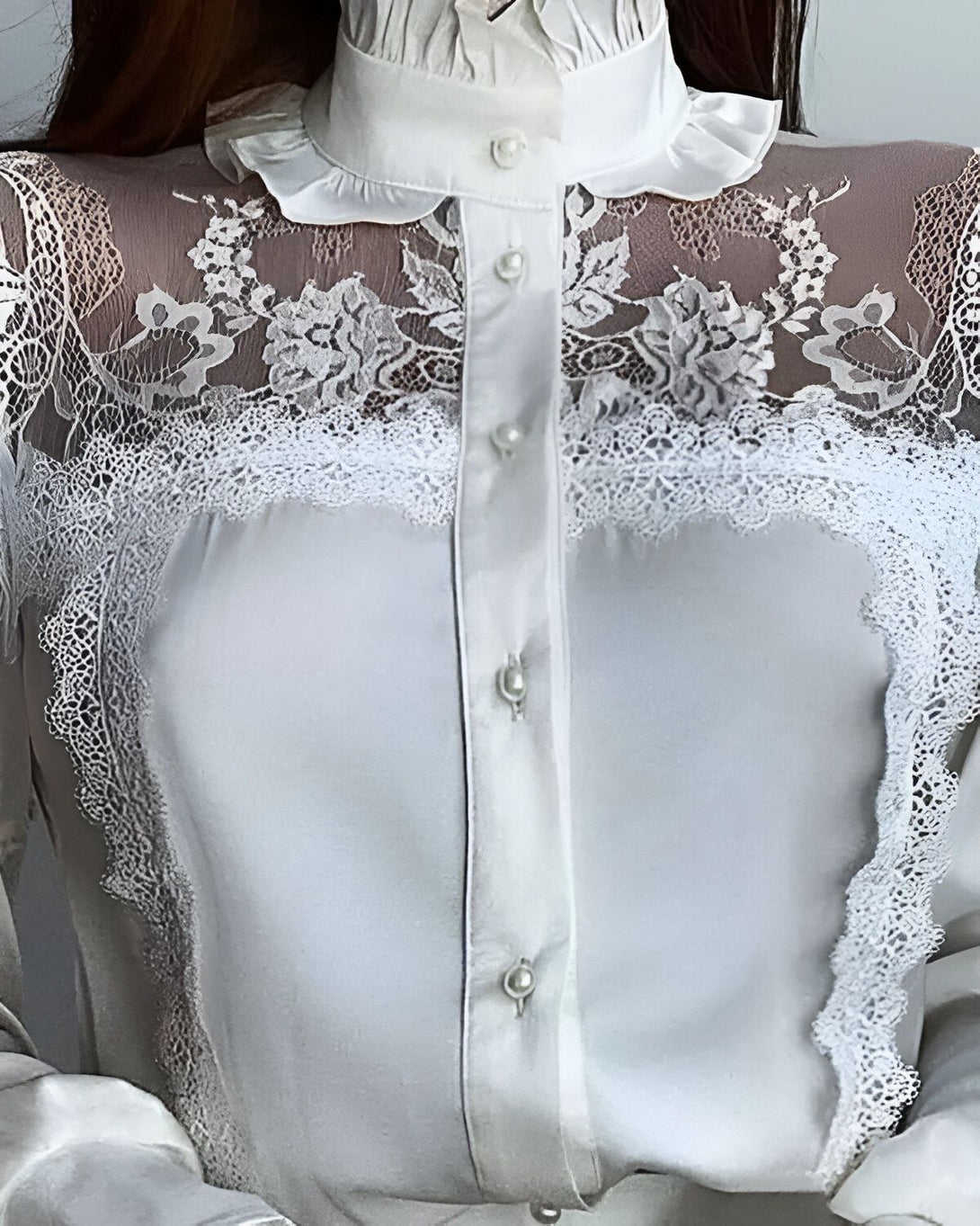 Chemisier blanc en dentelle avec un col montant et des manches longues.