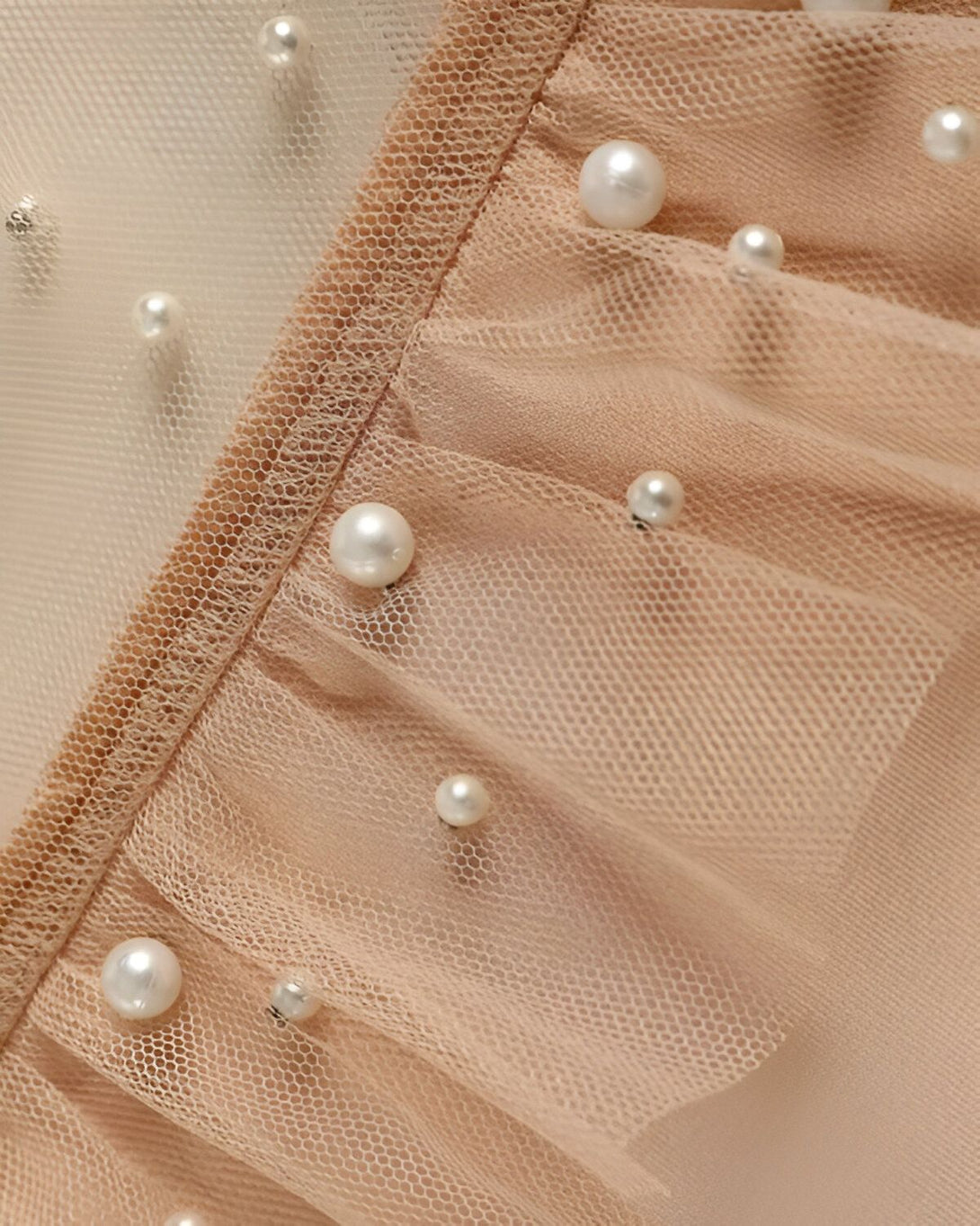 Image d'un tissu beige avec des perles cousues dessus.