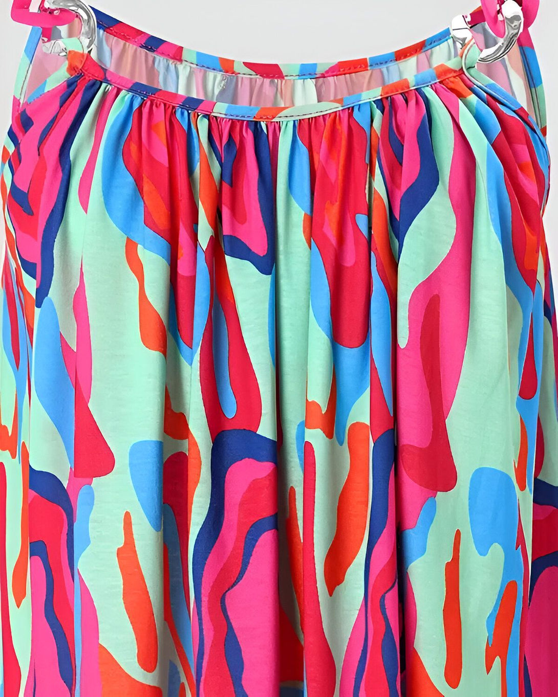 Une image d'une robe colorée avec un motif abstrait. La robe est principalement rose, verte et bleue.